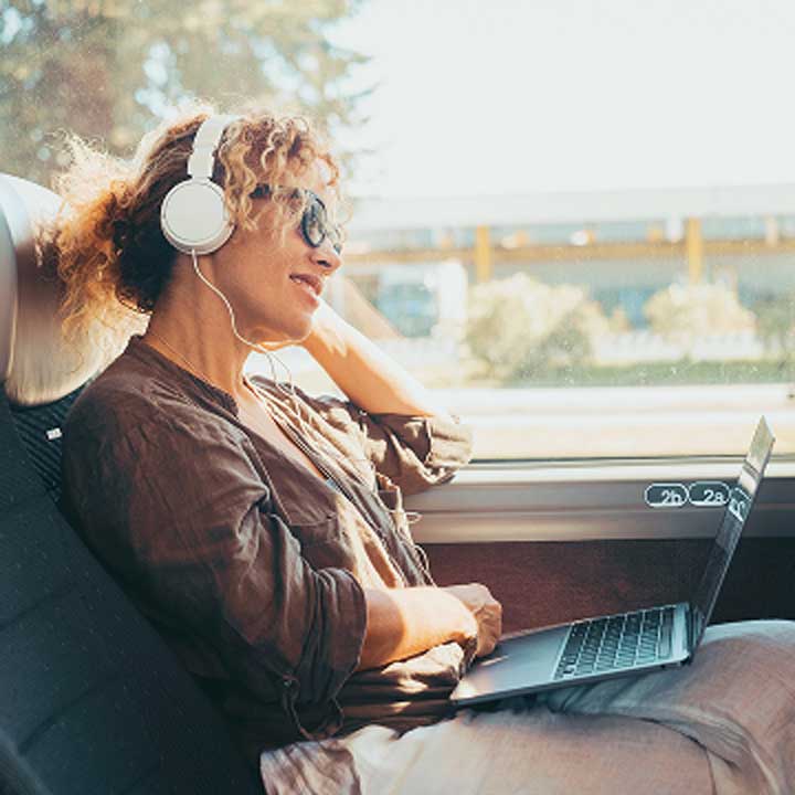 A woman with headphones is sitting in a bus