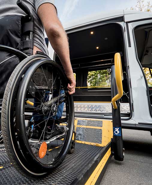 A person in a wheelchair is boarding a bus via wheelchair ramp